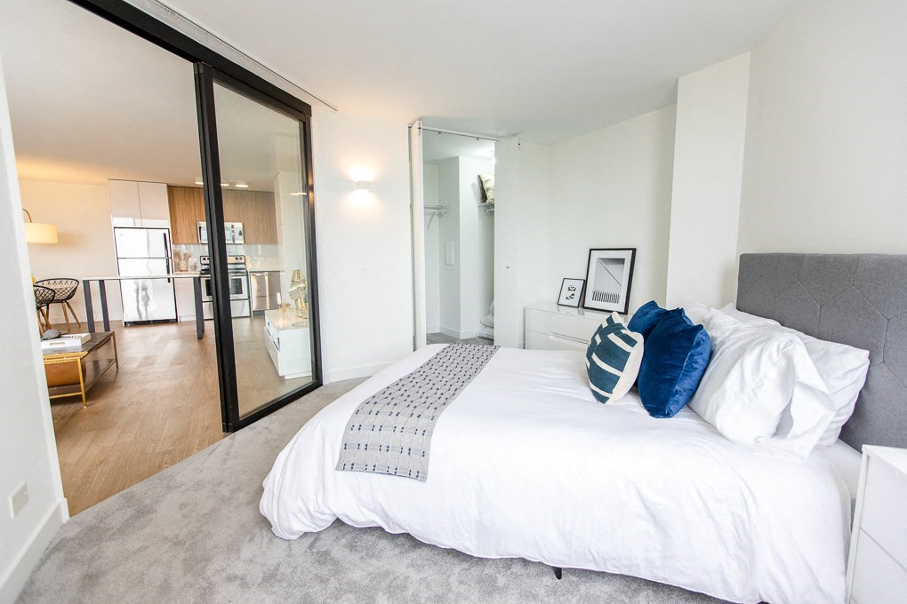a bedroom with a large bed and a sliding glass door at The Kent, Chicago, 60614