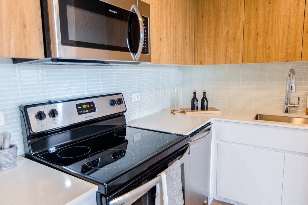 a small kitchen with a stove and a microwave at The Kent, Chicago, IL, 60614