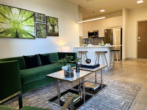 A modern living room with a green couch and a coffee table.