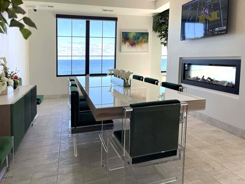 a dining room with a glass table and chairs and a fireplace at 42 Hundred On The Lake, St Francis, WI