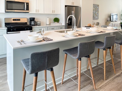 a kitchen with a counter top and chairs