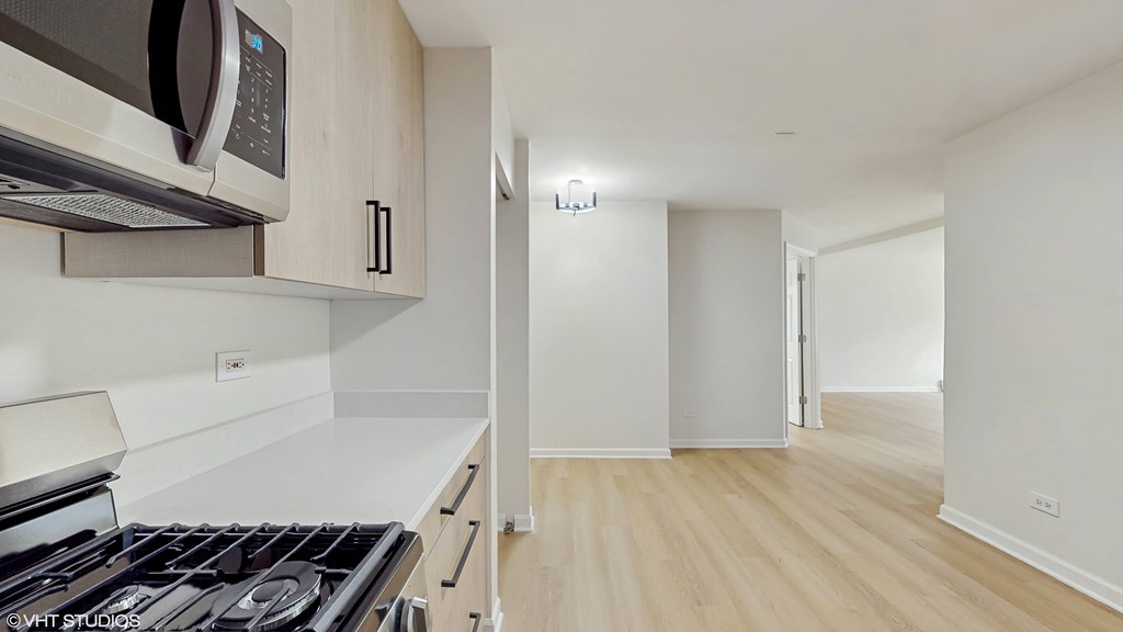 A kitchen with a stove, microwave, and oven.