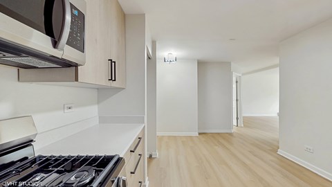 A kitchen with a stove, microwave, and oven.