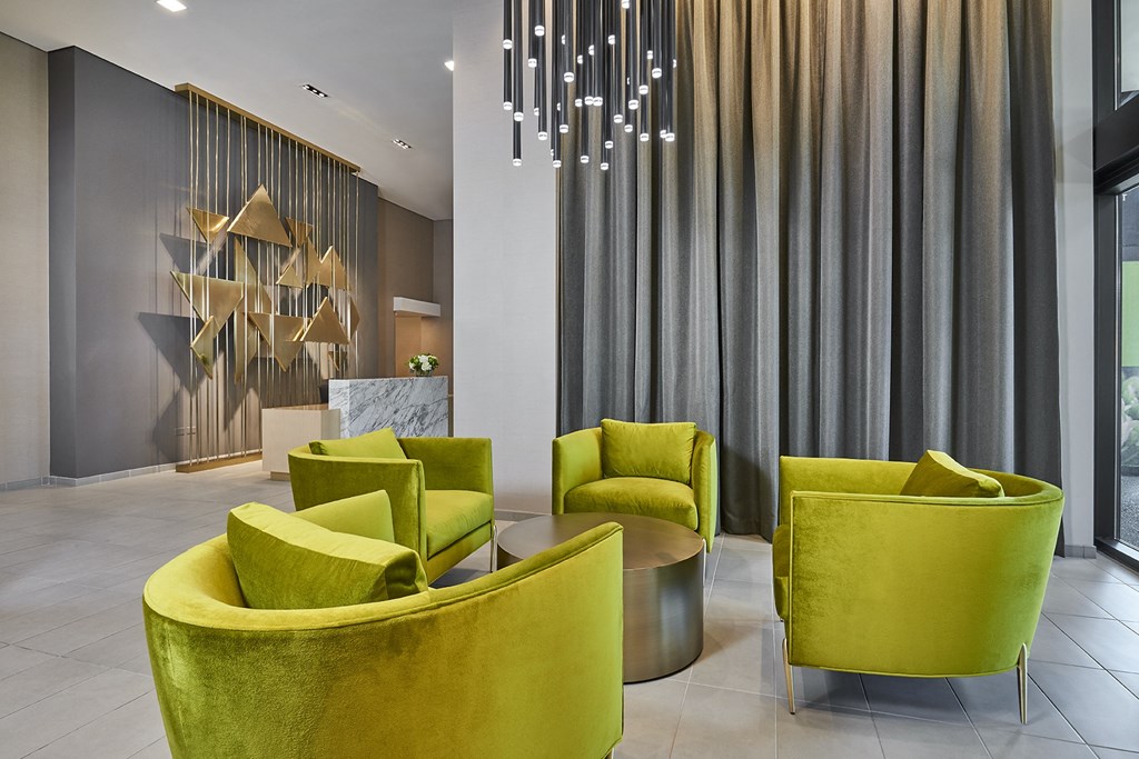 a large lobby with yellow chairs and a large chandelier at The Kent, Chicago, 60614