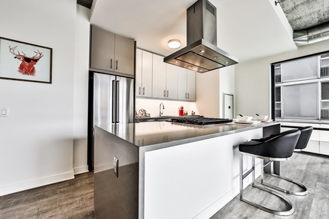 a kitchen with an island and a stove and a refrigerator