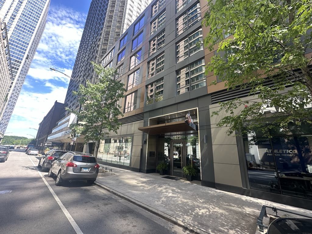a city street with cars parked in front of a tall building