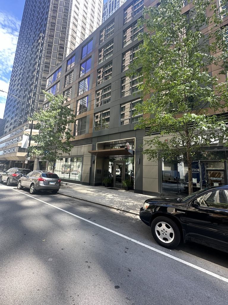 a city street with cars parked in front of a tall building