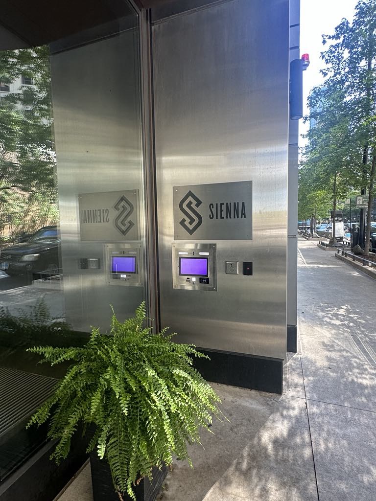 the front of a sigma building with a fern in front of the door