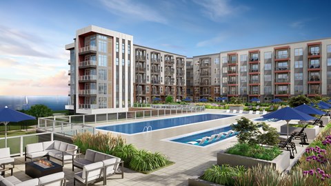 A modern apartment complex with a pool and outdoor seating area.