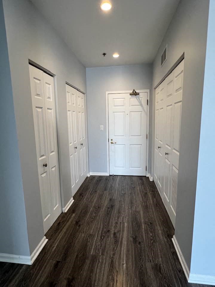 a hallway with a wood floor and white doors
