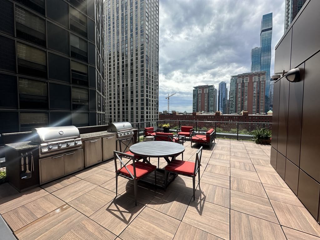 a patio with a table and chairs and a city in the background