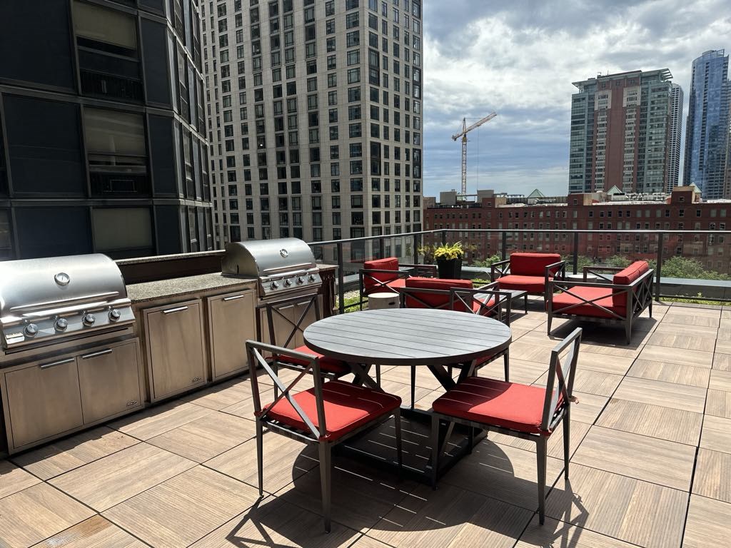 a patio with a table and chairs on a rooftop
