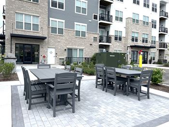 a patio with a table and chairs in front of an apartment building at Enclave Crystal Lake Townhomes and Apartments, Illinois, 60014