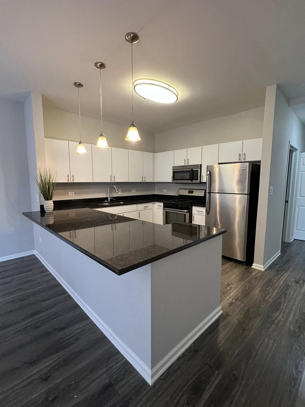 a kitchen with an island and a stainless steel refrigerator