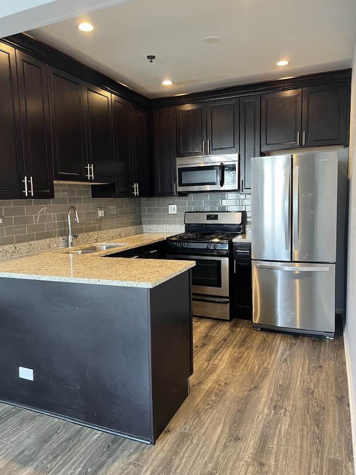 a kitchen with stainless steel appliances and black cabinets