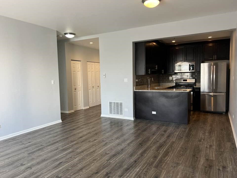 a kitchen and a living room with wood flooring
