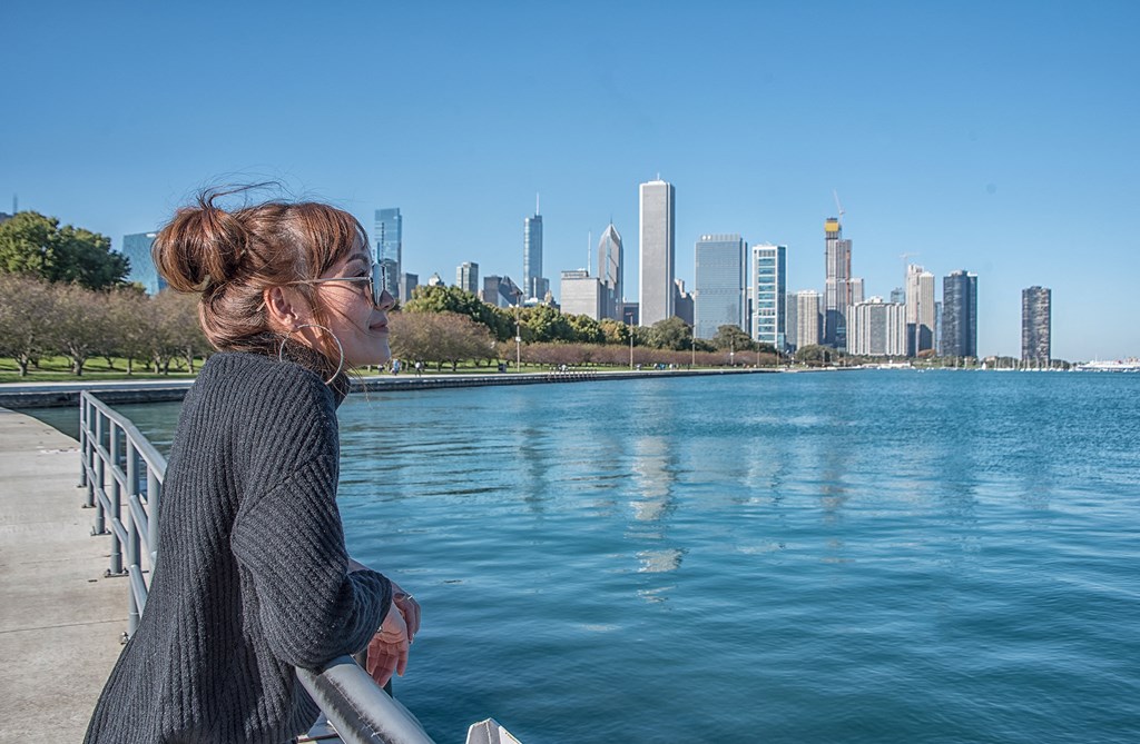 A woman in a black sweater is looking at a city skyline at The Kent, Chicago, Illinois, 60614