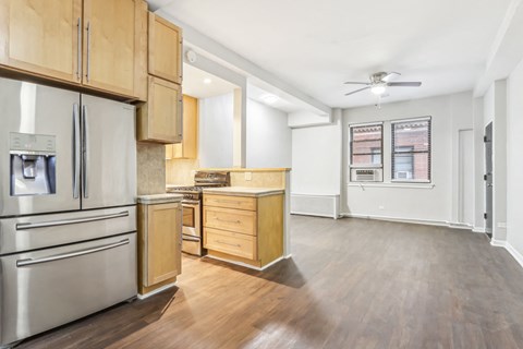 A kitchen with wooden cabinets and a stainless steel refrigerator.