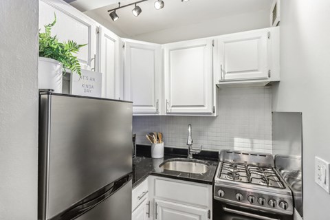 A kitchen with a stainless steel refrigerator and a stove top oven.