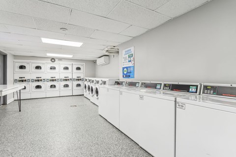 A laundry room with washing machines and a table.