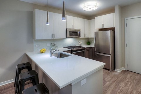 A kitchen with white cabinets and a white countertop.