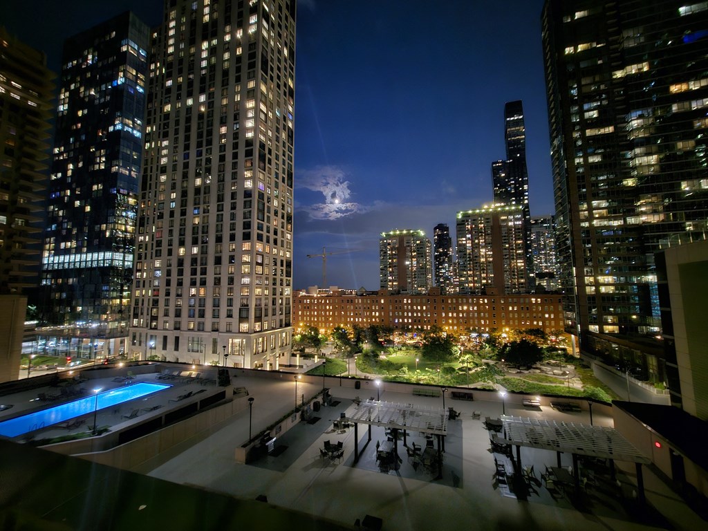 a view of the city at night from a rooftop terrace