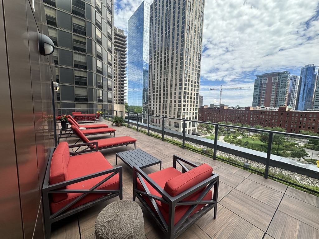 a balcony with red chairs and a view of skyscrapers