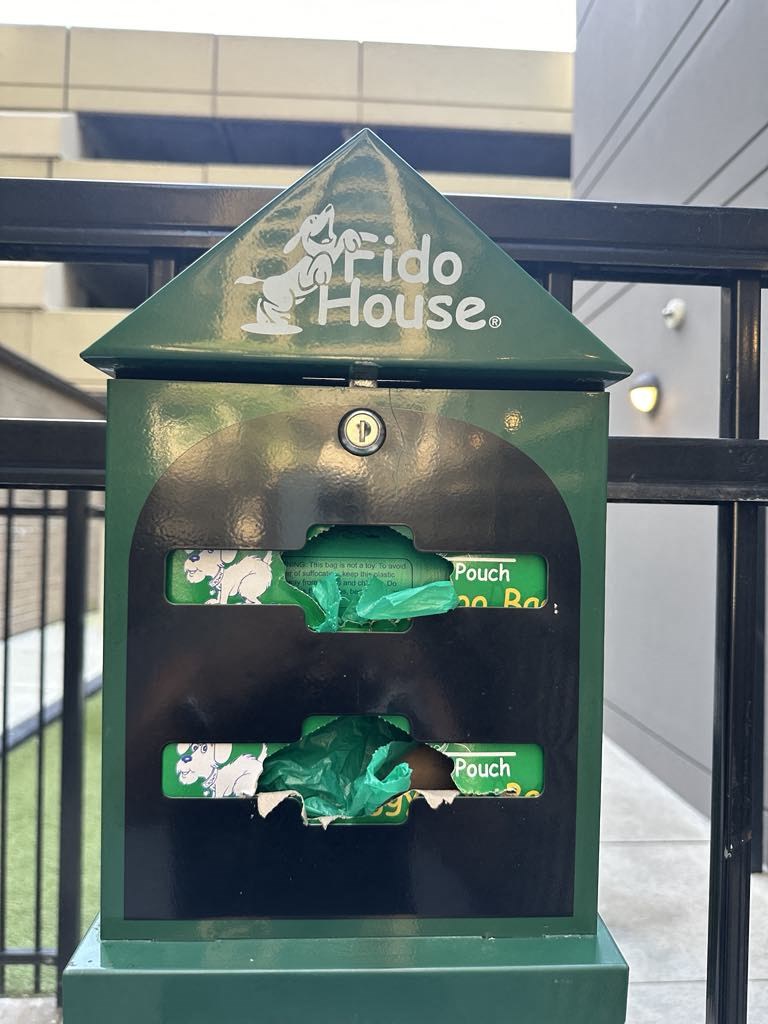 a bird house with a green bird figurine in it