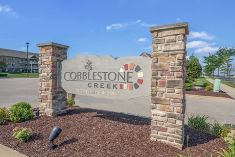 Cobblestone creek sign in front of a building.