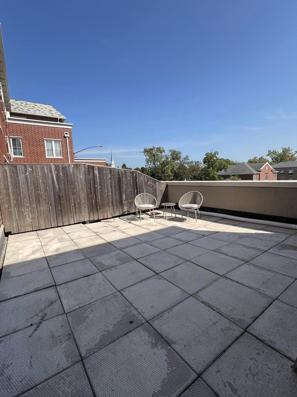 a patio with a table and chairs on a roof