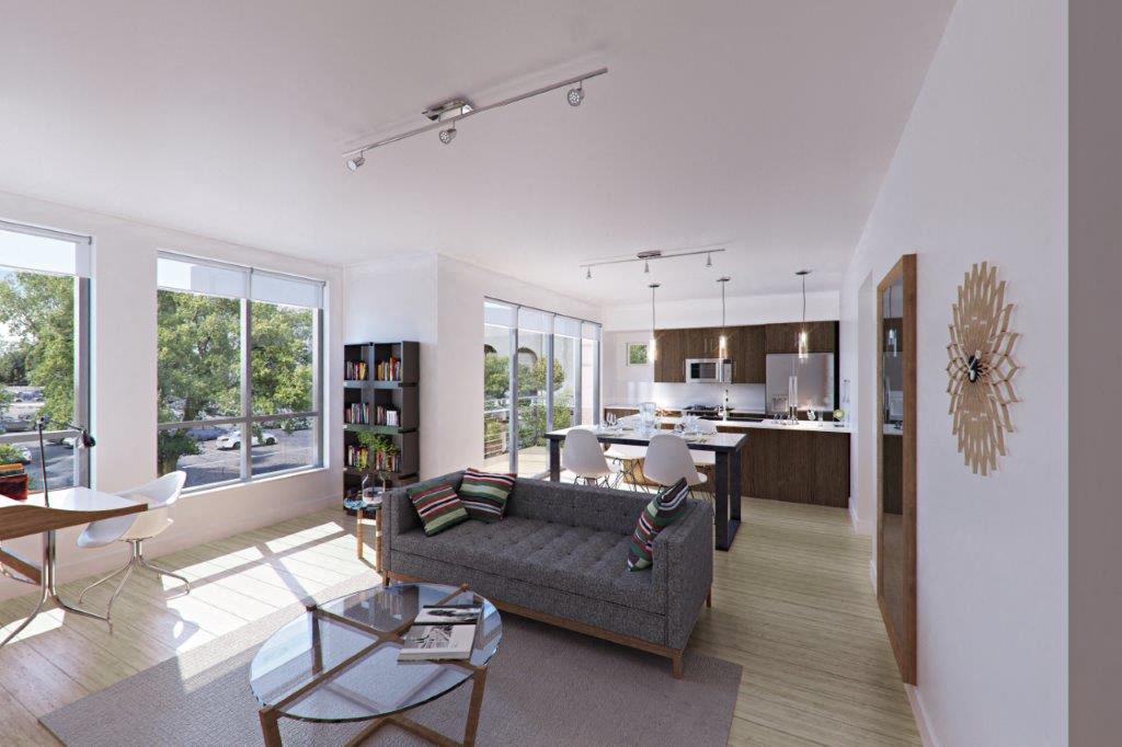 A modern living room with a grey sofa and a glass coffee table.