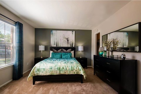 An apartment bedroom with a large bed and a dresser at 1601 Eastchase Pkwy in Fort Worth, TX.