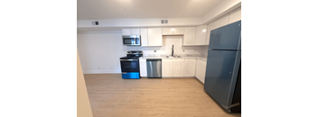A kitchen with a blue fridge and a black stove.