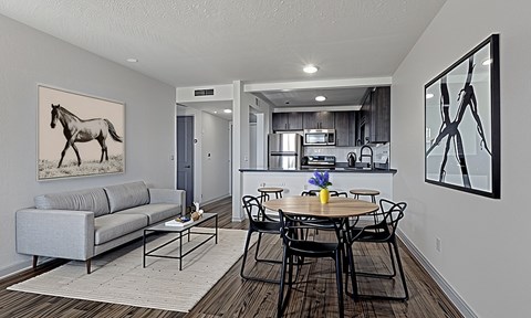 The Canvas Apartments Nashville TN living room with a grey couch and a painting of a horse on the wall.
