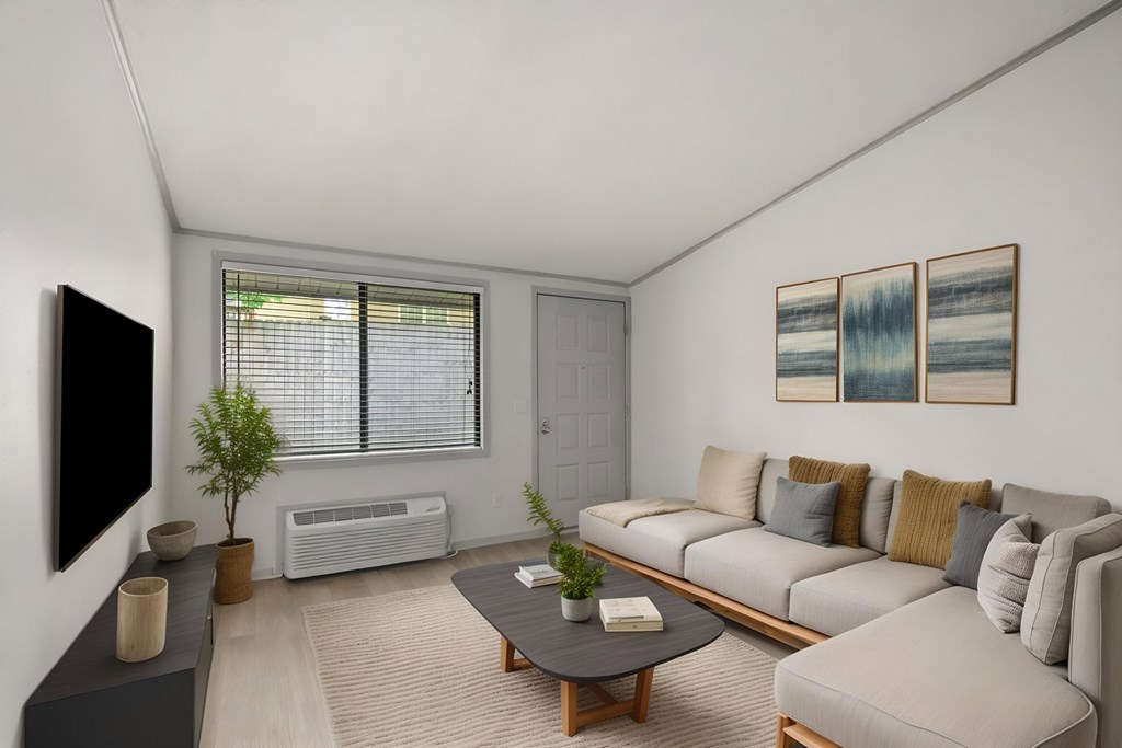 Retreat at Indian Lake apartments in Hendersonville, TN living room with a grey couch, a black coffee table, and a flat screen TV mounted on the wall.