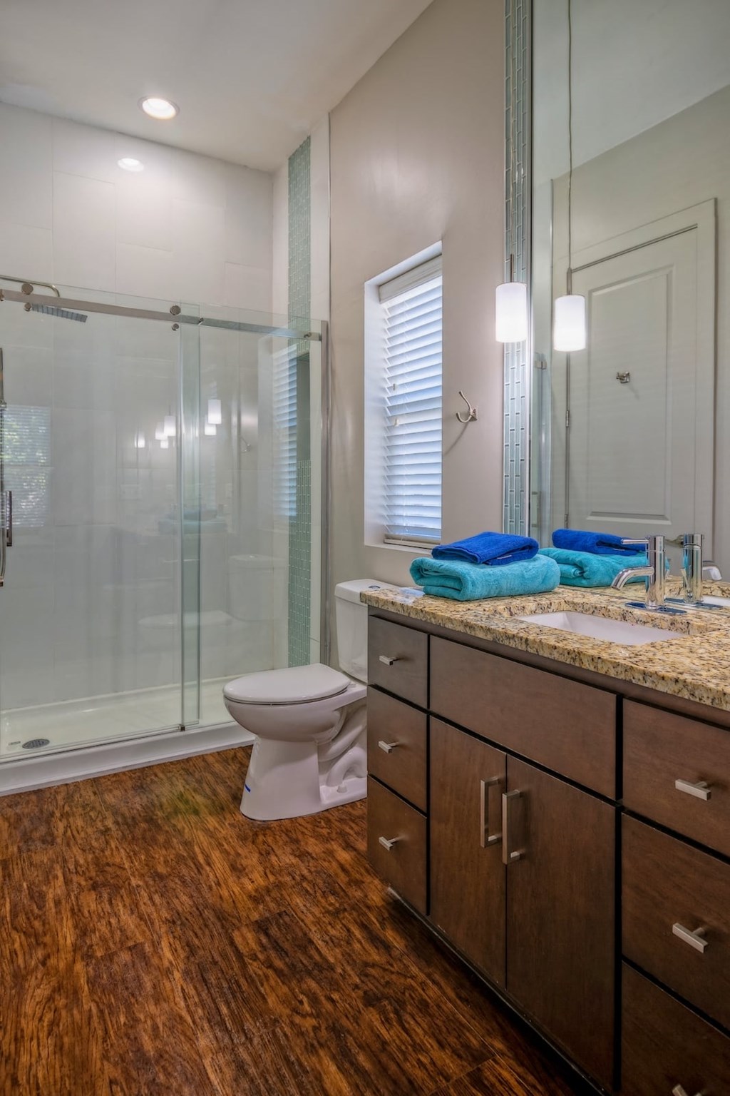 Bathroom in State Street Flats one bedroom apartment in Nashville with a rain shower and wide vanity with single sink and storage drawers.