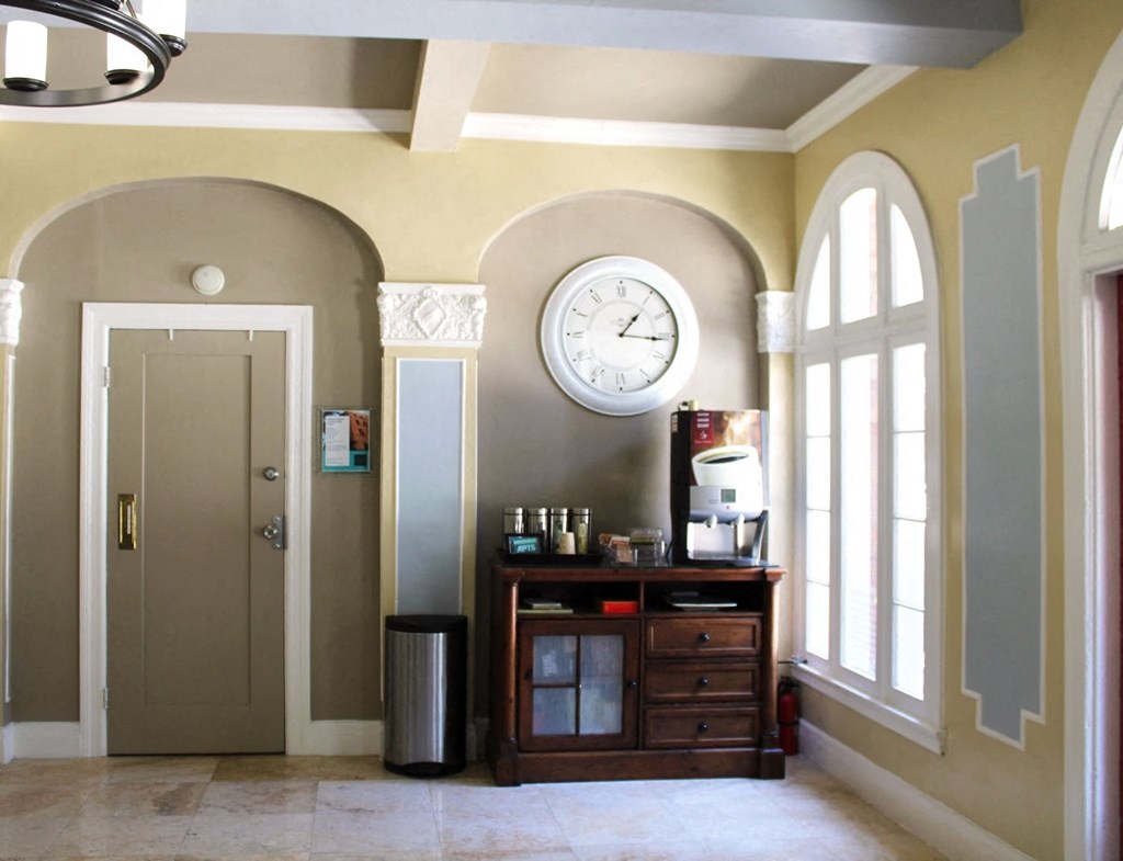Lobby in Brookmore Apartments in Pasadena with large arched windows and coffee station.