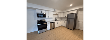 A kitchen with white cabinets and a black stove top oven.