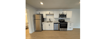 A kitchen with white cabinets and stainless steel appliances.