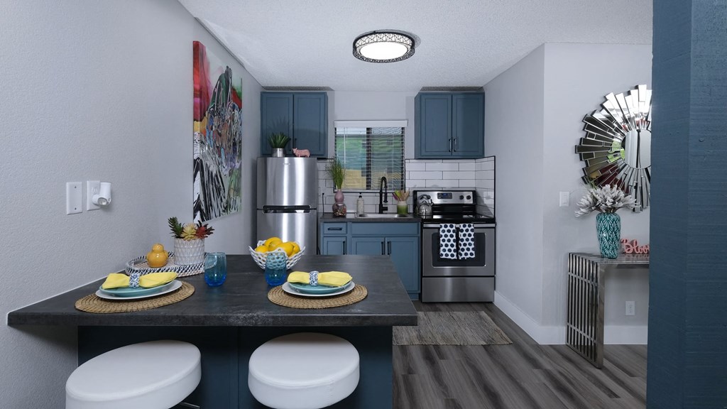 Fusion Las Vegas apartment kitchen with blue and yellow dinette place settings and modern console table with blue vase.