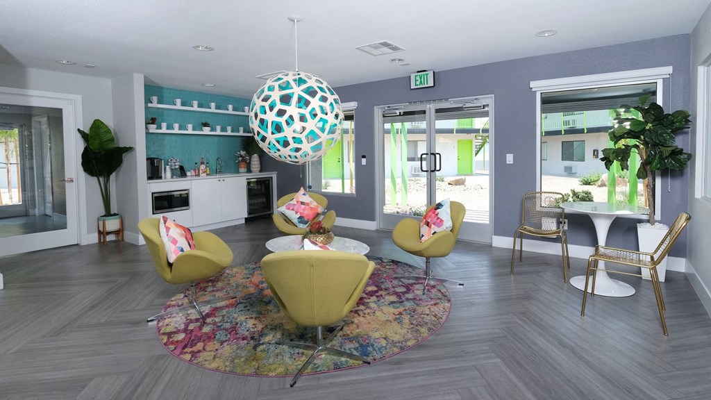Fusion Las Vegas apartments lobby with modern sitting area and coffee corner with appliances on grey herringbone flooring.