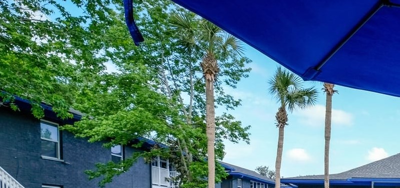Swimming Pool View of Community pool from blue patio table with umbrella and chairs. Pool is in the middle of Mandarin Bay Apartments in Jacksonville, 32257