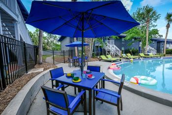 poolside table with umbrella at Mandarin Bay apartments in Jacksonville, FL