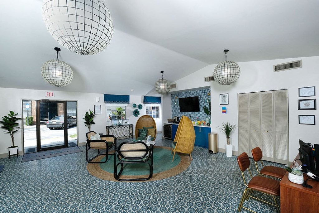 Rent an apartments in Lakeland, FL at Watermarc Apartments - leasing office with Spanish-inspired tile floor and sitting area next to a coffee bar.