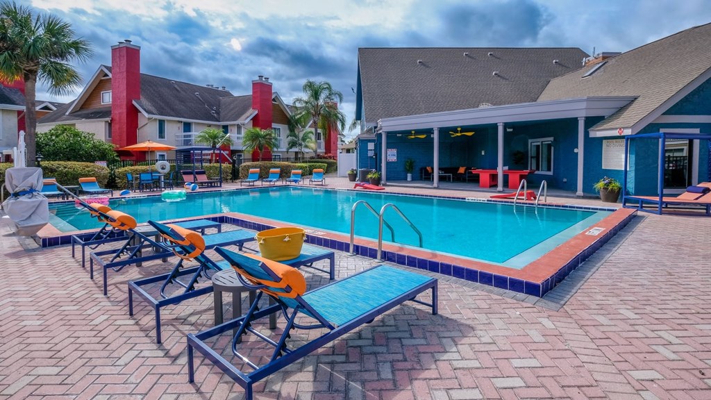 Fusion Orlando apartments community pool and large pool house next to two story apartment buildings with red chimneys