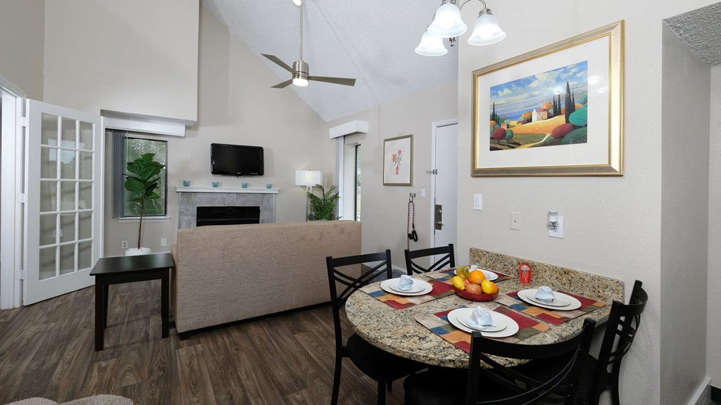 Fusion Orlando apartment living room view from kitchen with dinette breakfast nook set with four rustic colored placemats and white plates