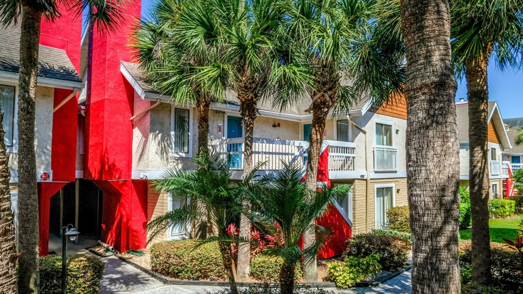 Fusion Orlando apartments exterior shot of buildings with red chimneys and balconies with white railing surrounded by palm trees