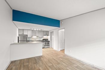 A kitchen with white countertops and a blue stripe on the wall at The Retreat at Indian Lake Apartments.