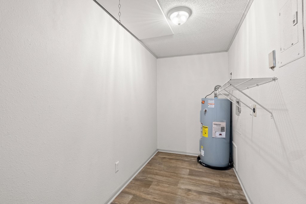The Retreat at Indian Lake Apartments for rent in Hendersonville TN room with a grey water heater and wooden floor.