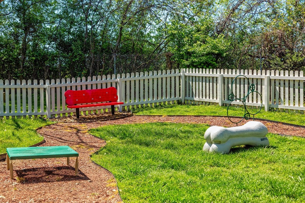 Pet park at the Retreat at Indian Lake apartments in hendersonville with red park bench and dog agility course equipment.
